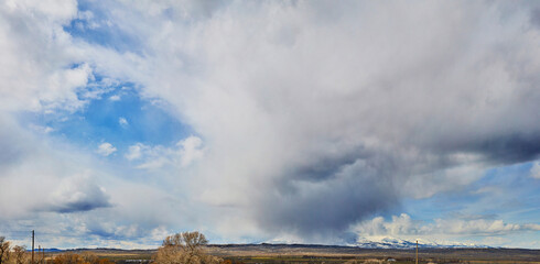 Panorama of large storm overtaking snowy mountains