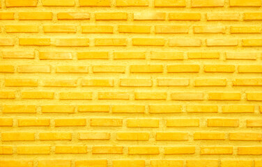 Brick wall painted with yellow paint pastel bright tone texture background. Brickwork and stonework flooring interior.