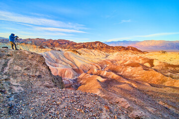Photographer capturing stunning sunrise in majestic desert mountains of Death Valley