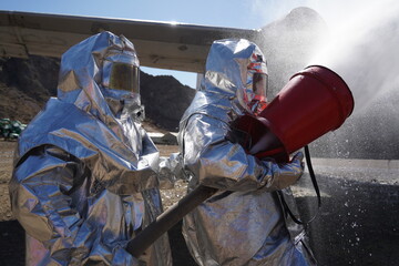 Almaty, Kazakhstan - 09.22.2021 : Rescuers in special protective suits extinguish the plane in...
