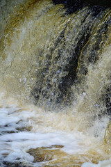 Rapid water stream in waterfall on small river.