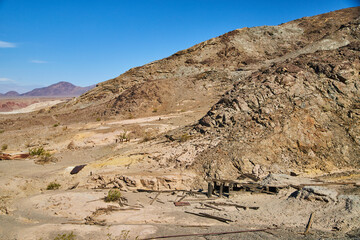 Rocky desert mountains up close with decayed wood structures