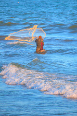 Fisherman throwing fishing net with sunset background - Mersin, Turkey