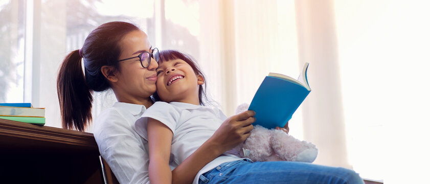 Asian children schoolgirl with mother reading books in library