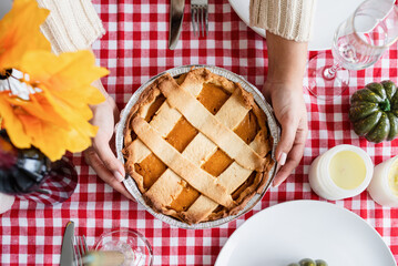 top view of woman preparing pumpkin pie for thanksgiving dinner at home kitchen