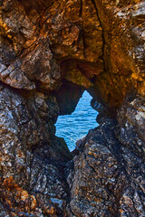 Ocean view seen through tunnel of sharp rocks
