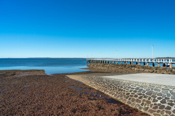View past boat ramp and jetty to the blue waters of Moreton Bay, at Wellington Point, Queensland, Australia 