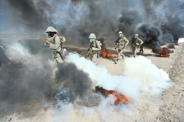 Almaty, Kazakhstan - 08.22.2012 : Soldiers pass a burning obstacle course in gas masks.