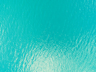 Fototapeta na wymiar Aerial view of a Crystal clear sea water texture. View from above Natural blue background. Turquoise ripple water reflection in tropical beach. Blue ocean wave. Summer sea. Drone. Top view