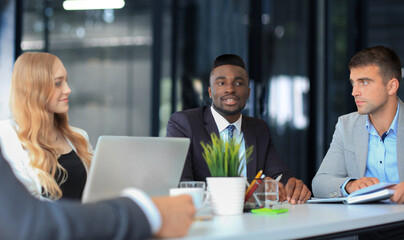Business people in discussing something while sitting together at the table.