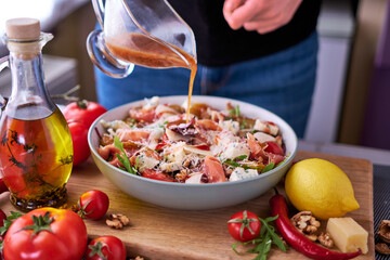 Salad with jamon or prosciutto, pears, tomatoes and arugula on wooden board