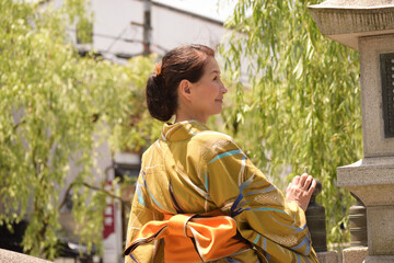 浴衣を着て温泉街で振り向く笑顔のシニア女性