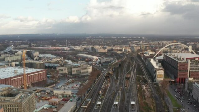 Forwards fly above railway transport infrastructure in suburb. Crossing of railway lines with multiple bridges over busy street. Cologne, Germany