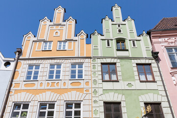 Historical houses with yellow and green facade in the old town of Landshut.
