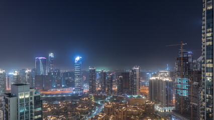 Obraz na płótnie Canvas Aerial panoramic view of a big futuristic city night timelapse. Business bay and Downtown
