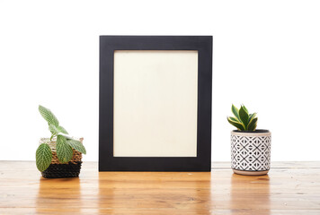 Frame on Wooden Table with Plants