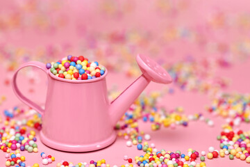 Small multicolored polyfoam balls in a miniature water can.