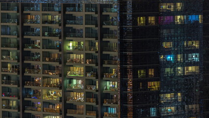 Fototapeta na wymiar Windows of apartment building at night timelapse, the light from illuminated rooms of houses