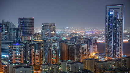 Fototapeta na wymiar Skyscrapers in Barsha Heights district and low rise buildings in Greens district aerial night timelapse.