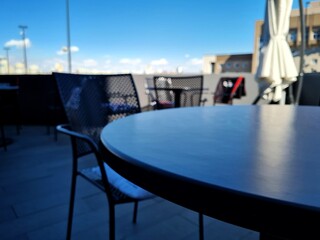 Summer veranda with black tables and chairs outside