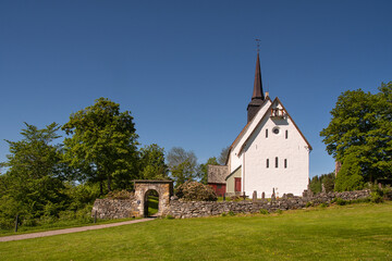 Fototapeta na wymiar Tingvoll church, Nordmørsdomen, Norway. This church is a white stone church from 1180. Beautiful surroundings. 