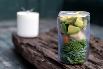 Healthy green smoothie avocado and kale mixed fruits, yogurt and honey in portable blender. Kale is considered a superfood because it's a great source of vitamins and minerals.