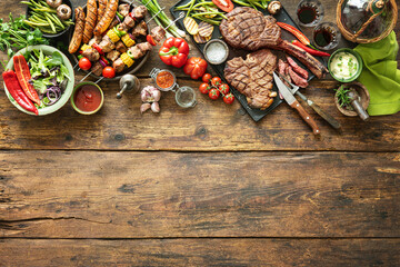 Grilled meats and vegetables on rustic picnic table