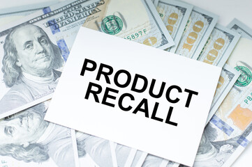 Product Recall inscription on the card on the background of dollar bills, business concept