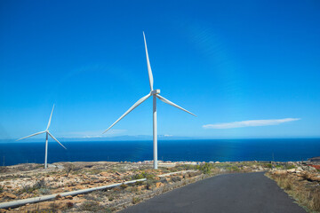 Clean energy concept. Wind turbine farm agaist the blue sky to generate renewable energy for prevention of global warming