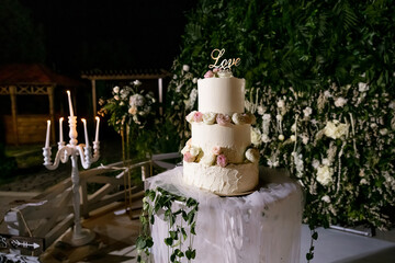 wedding three-tiered white cake decorated with flowers.