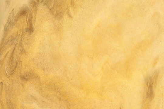 Abstract fluid art background golden colors. Watercolor painting on canvas with soft yellow gradient. Brush stroke texture for design. Oil painted high resolution seamless texture. Copy space 