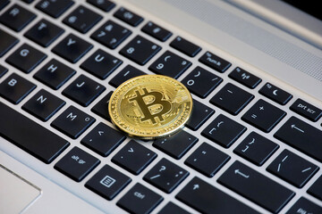 Bitcoin on laptop keyboard. Electronic decentralized money, crypto currency