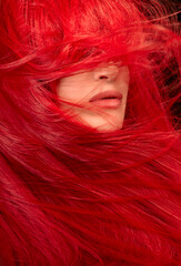 Hair care and fashion concept. Beauty portrait of a woman with windswept long red hair