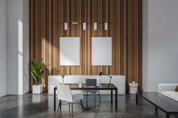 Stylish office room interior with desk and laptop, couch and mockup frames