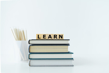 Book or textbook stack and pencil with word LEARN. Skill improvement for student or businessperson. Studying and training course online at home. Business success idea, education learning concept