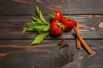ripe organic strawberries scattered in a row on a brown wooden background. place for text
