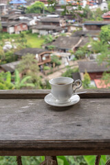Cup of coffee on wooden table and blurred background.