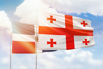 Sunny blue sky and flags of georgia and dominican republic