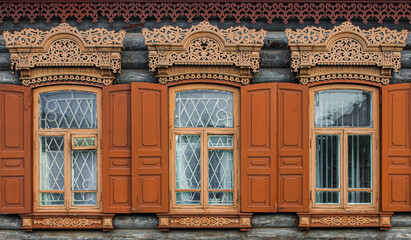 A window with wooden carved sashes. Wooden architecture