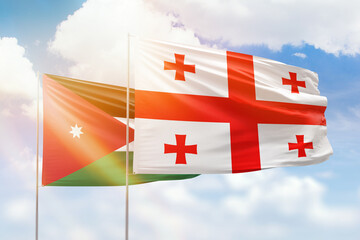 Sunny blue sky and flags of georgia and jordan