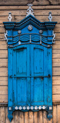A window with wooden carved sashes. Wooden architecture