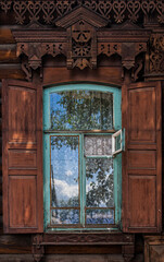 A window with blue brown wooden shutters. Wooden architecture
