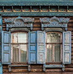 A window with wooden carved sashes. Wooden architecture