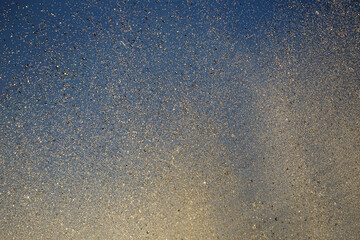 Bright splashes of the water fountain against the blue sky. Abstract color composition in sunshine backlight.