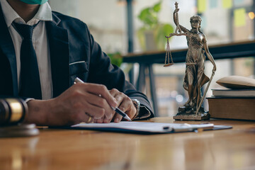 Business lawyers work hard at their desks with books and papers. The judge uses a hammer at the justice attorney. Lawyer's Office The goddess of justice and the scales of the law. advice 