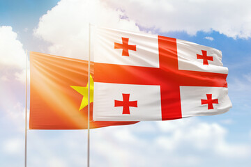 Sunny blue sky and flags of georgia and vietnam