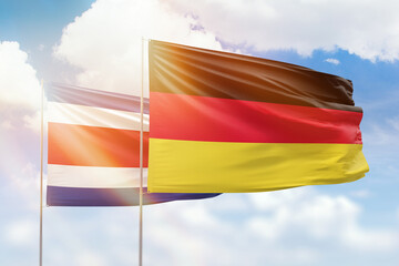 Sunny blue sky and flags of germany and costa rica