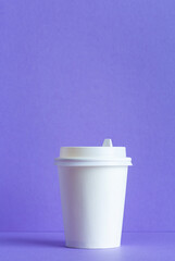 White paper cup on purple background