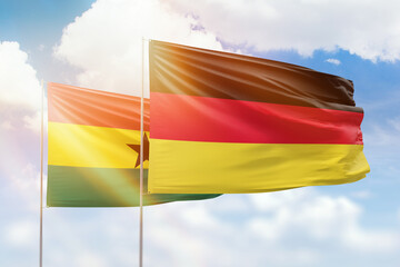 Sunny blue sky and flags of germany and ghana