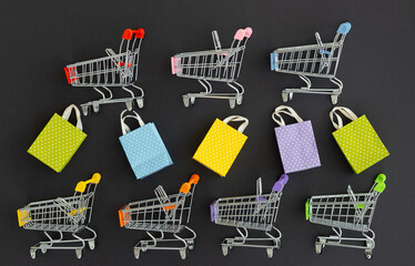 Small paper shopping bags with shopping cart on black background